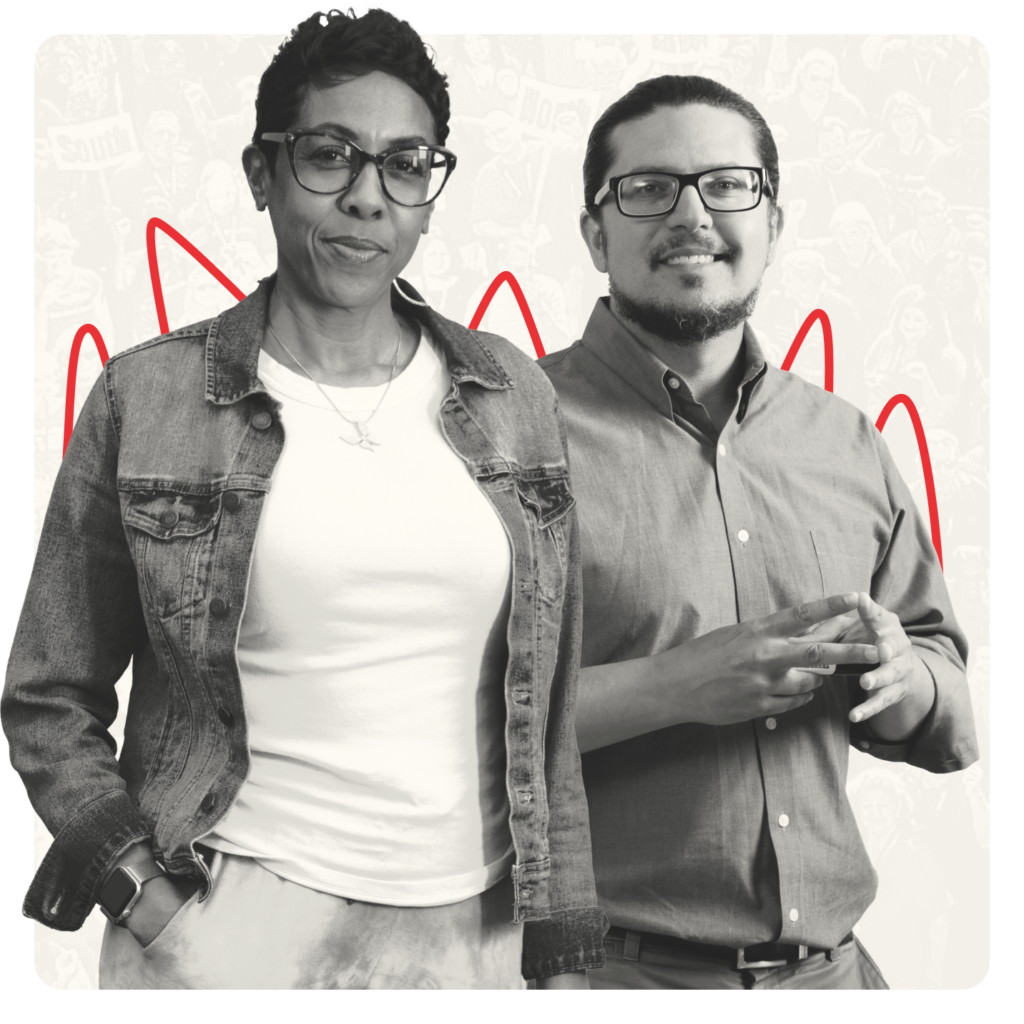 Female educator with glasses stands, hands in pockets, next to male educator with glasses, with hands grasped at his chest